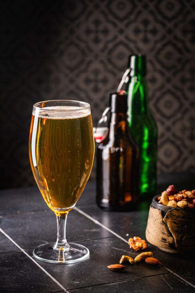 Glass of light beer on dark background. Selective focu